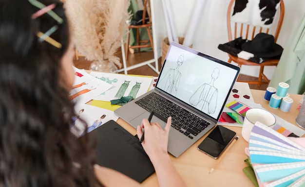 Girl draws a sketch of clothes on a laptop