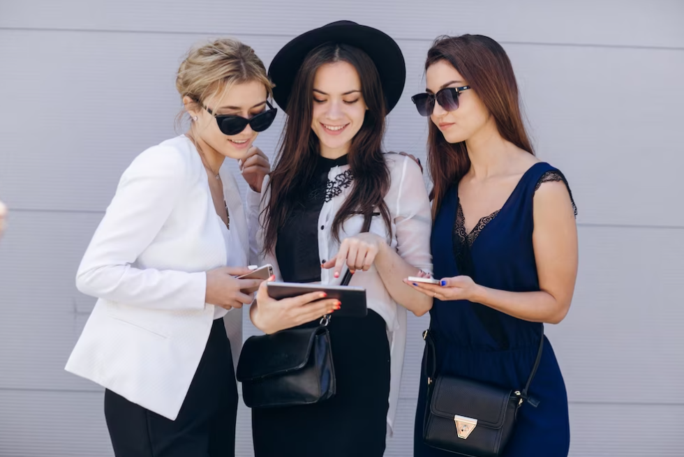 three women look at the tablet, one is pointing on it