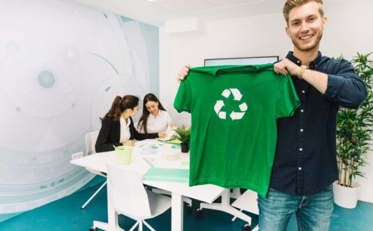 Man showing green t-shirt with recycle symbol