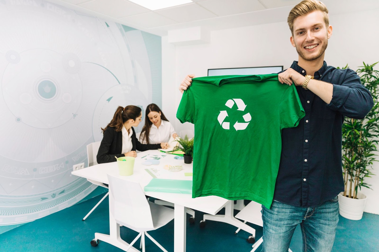 Man showing green t-shirt with recycle symbol